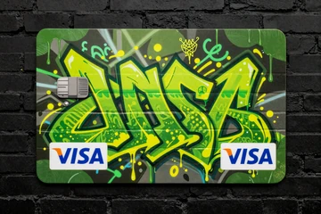 Als Street-Art gemalte Visa-Kreditkarte mit Neon-Spray-Paint auf dunkler Backsteinmauer