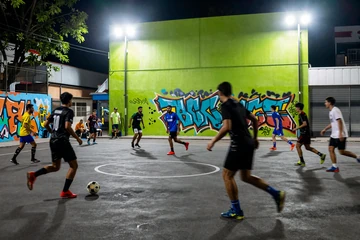 Street-Football-Match bei Nacht unter Neon-Flutlichtern mit Motion-Blur bei Golisimo Live-Wetten
