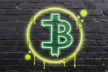 Street-Art Tether USDT Krypto-Symbol als Neon-Spray-Paint auf dunkler Backsteinmauer